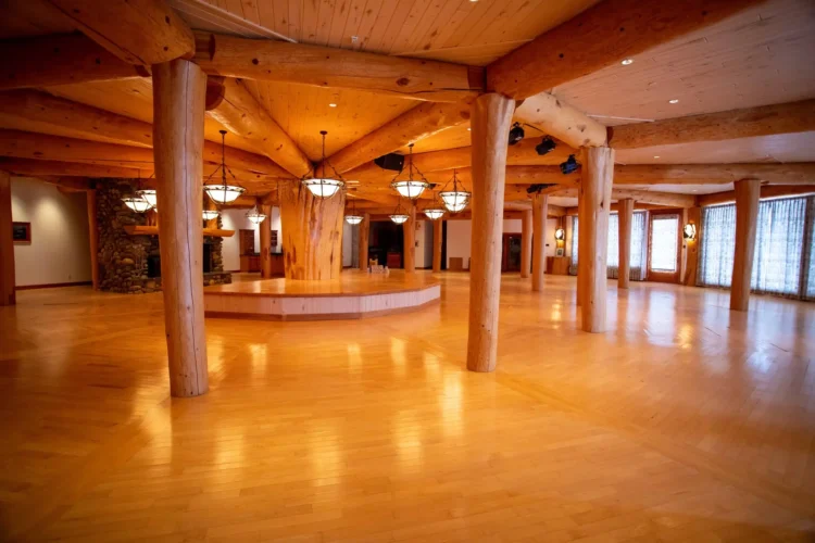 Gallery of the world's largest log home at Moberly Lake, featuring exterior views, the great room's 52ft ceiling, aerial shots, dining area, home theater, wine cellar, kitchen, and workout room with a pool and hot tub.