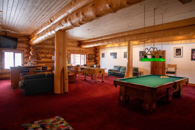 Gallery of the world's largest log home at Moberly Lake, featuring exterior views, the great room's 52ft ceiling, aerial shots, dining area, home theater, wine cellar, kitchen, and workout room with a pool and hot tub.