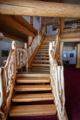 Gallery of the world's largest log home at Moberly Lake, featuring exterior views, the great room's 52ft ceiling, aerial shots, dining area, home theater, wine cellar, kitchen, and workout room with a pool and hot tub.