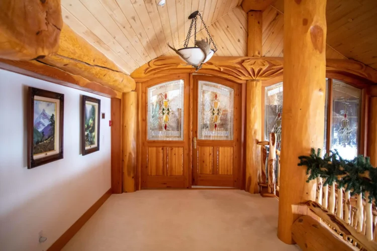 Gallery of the world's largest log home at Moberly Lake, featuring exterior views, the great room's 52ft ceiling, aerial shots, dining area, home theater, wine cellar, kitchen, and workout room with a pool and hot tub.