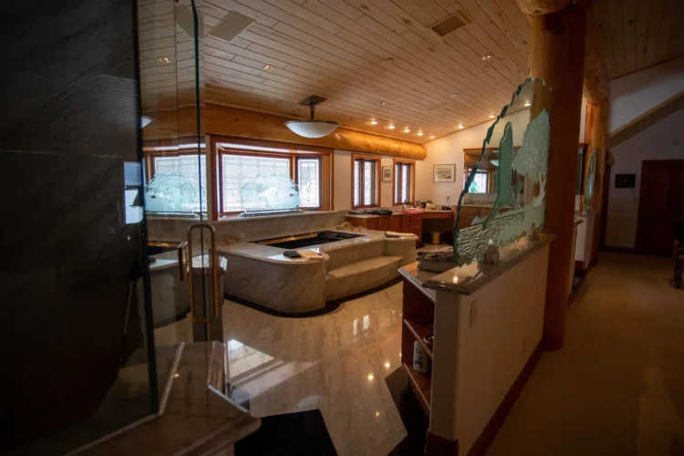 Gallery of the world's largest log home at Moberly Lake, featuring exterior views, the great room's 52ft ceiling, aerial shots, dining area, home theater, wine cellar, kitchen, and workout room with a pool and hot tub.