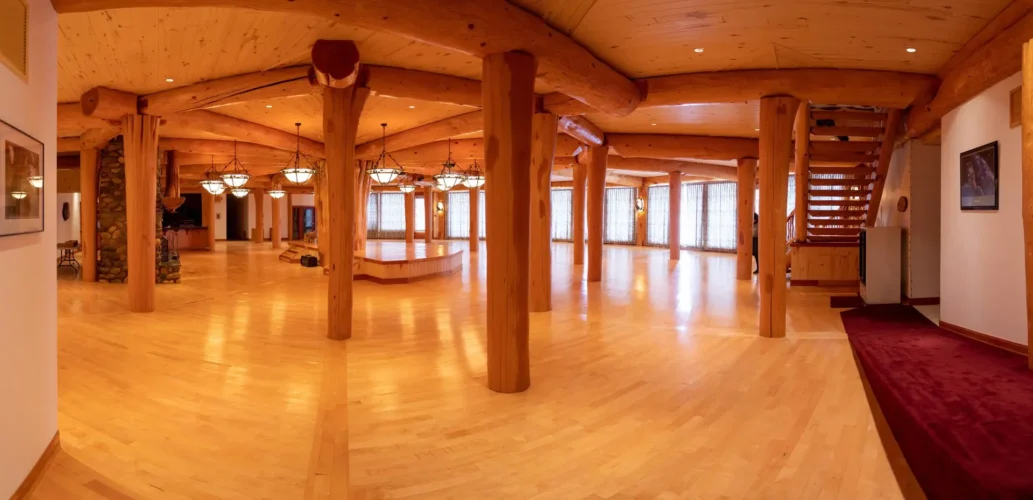 Gallery of the world's largest log home at Moberly Lake, featuring exterior views, the great room's 52ft ceiling, aerial shots, dining area, home theater, wine cellar, kitchen, and workout room with a pool and hot tub.