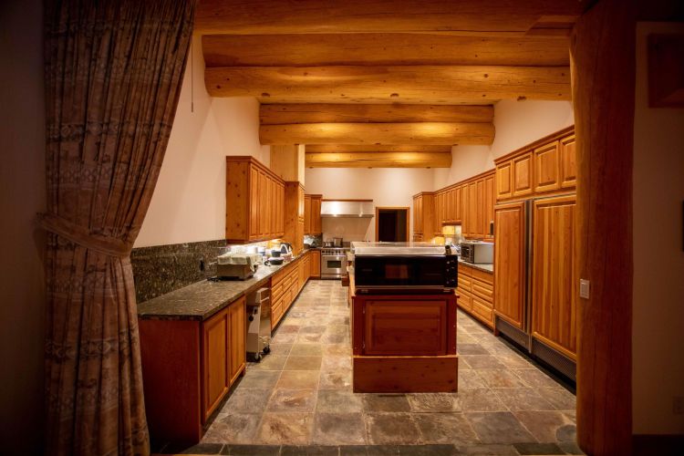 Gallery of the world's largest log home at Moberly Lake, featuring exterior views, the great room's 52ft ceiling, aerial shots, dining area, home theater, wine cellar, kitchen, and workout room with a pool and hot tub.